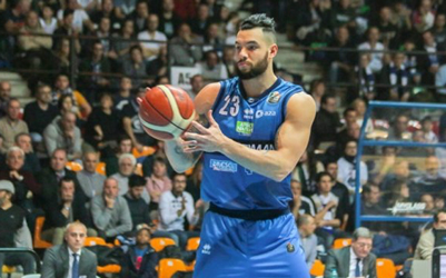 Christian Burns in his blue Germani Brescia uniform with a crowd in the stands behind him