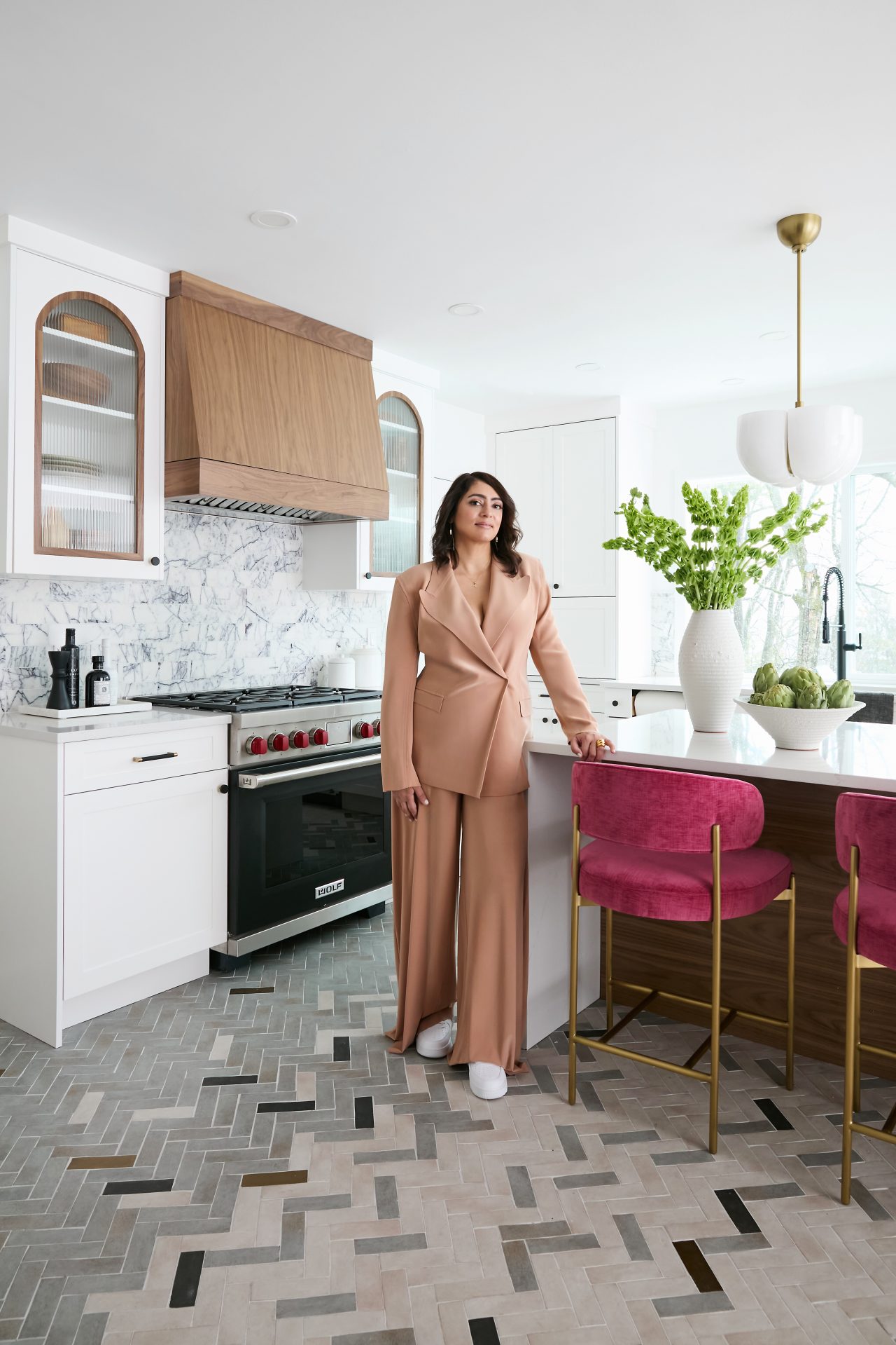 This image shows Nureed Saeed standing in a kitchen that she designed.